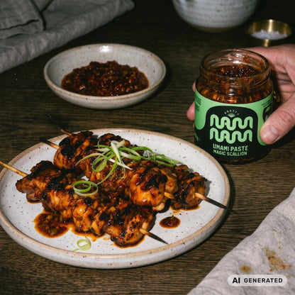 Glasierte Hähnchenspieße mit Frühlingszwiebeln, daneben eine Schale Umami Paste Magic Scallion